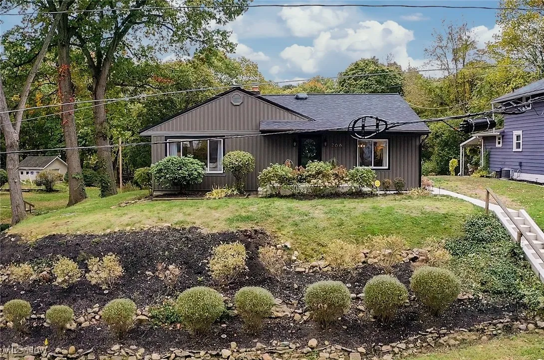View of front facade featuring a front lawn, board and batten siding, and a shingled roof
