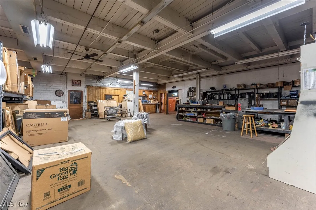 Garage featuring ceiling fan and a workshop area
