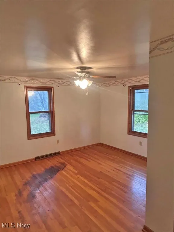 Empty room with light wood-style flooring and ceiling fan