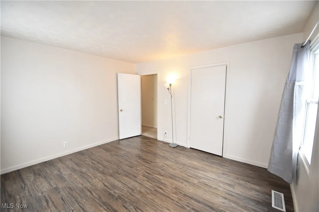 Unfurnished bedroom featuring dark wood-style flooring and a textured ceiling