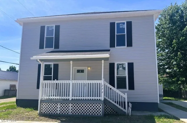 Traditional-style home featuring covered porch