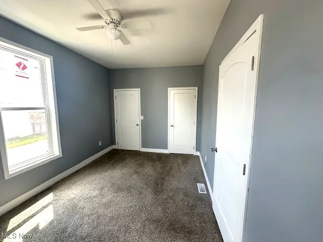 Unfurnished bedroom with carpet floors and a ceiling fan