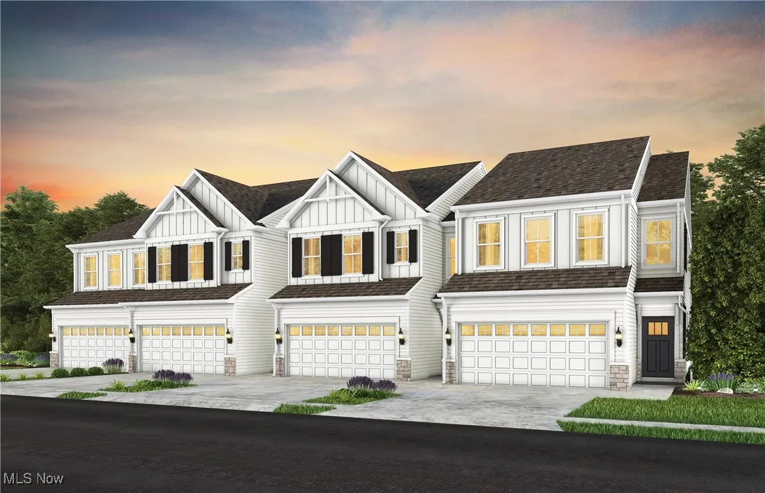 Modern farmhouse style home with board and batten siding, a garage, driveway, and stone siding