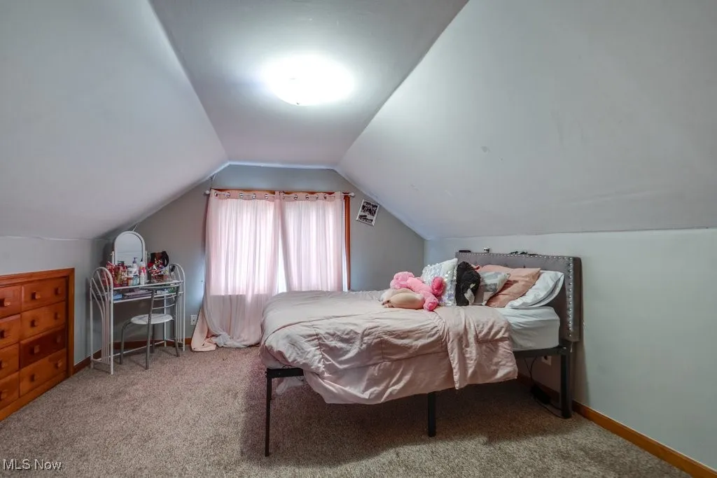 Bedroom with carpet flooring and lofted ceiling