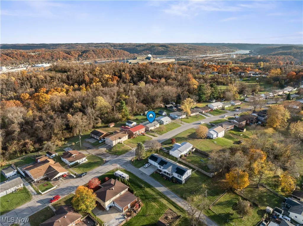 View of property location featuring nearby suburban area and a heavily wooded area