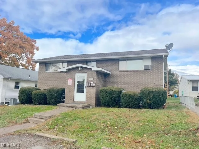 View of front of home with a front yard and brick siding