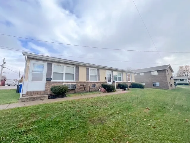 View of front facade with brick siding and a front yard