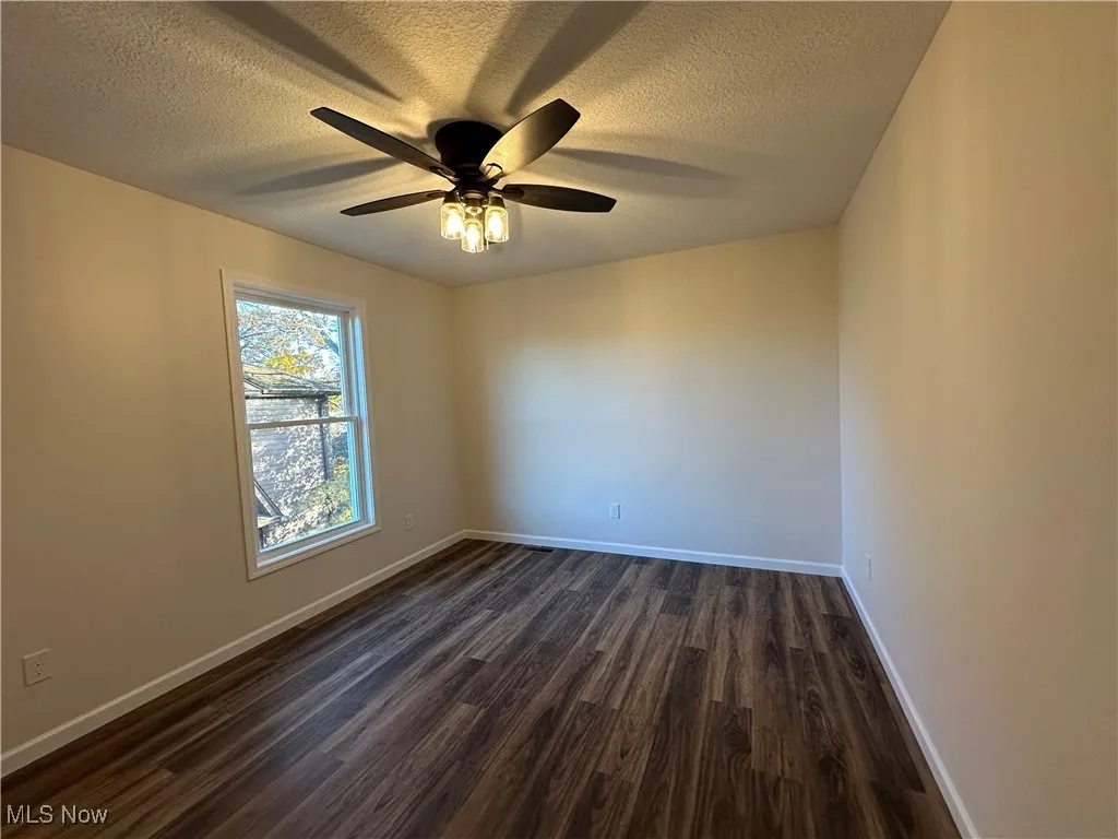 Bedroom featuring dark wood-style flooring and a textured ceiling
