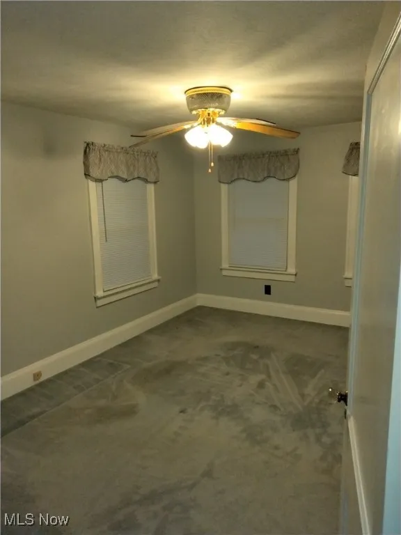 Unfurnished room featuring carpet floors and ceiling fan
