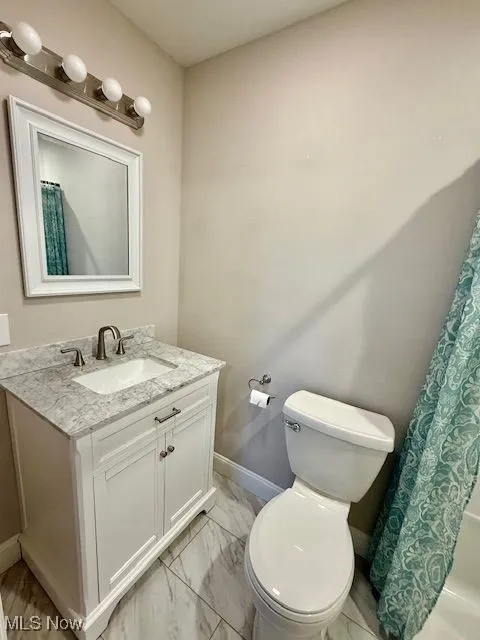 Bathroom with vanity and light marble finish floors