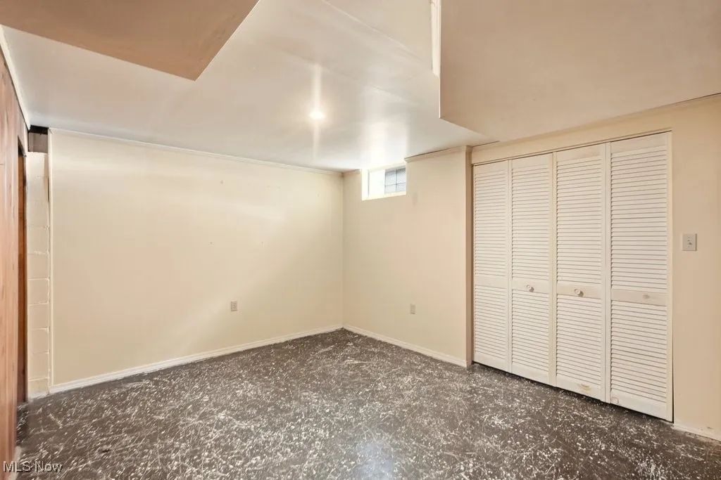 Unfurnished bonus room featuring a closet and baseboards