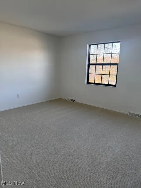 Unfurnished room featuring light colored carpet and baseboards