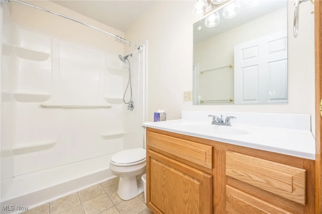 Full bathroom featuring vanity, a shower, and light tile patterned floors