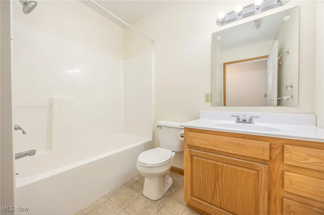 Bathroom featuring vanity, shower / bathtub combination, and light tile patterned floors