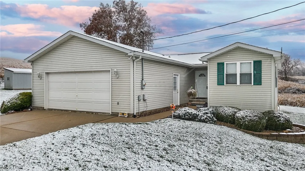Ranch-style house featuring concrete driveway and an attached garage
