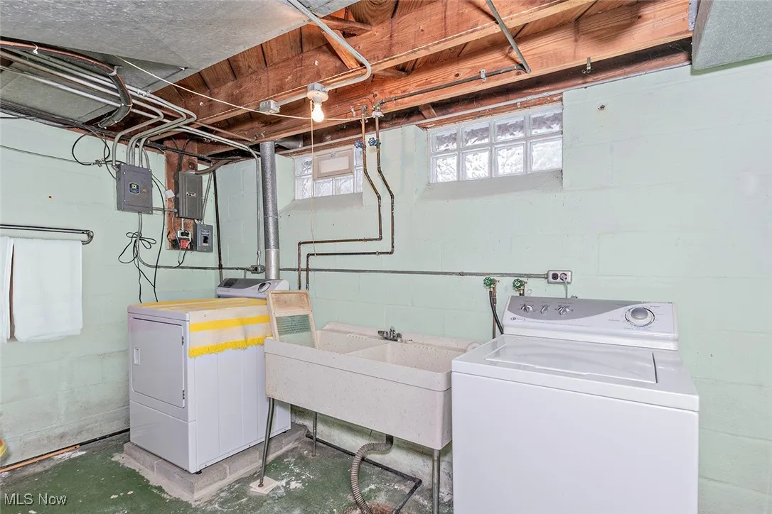Laundry area featuring unfinished concrete flooring and washing machine and clothes dryer