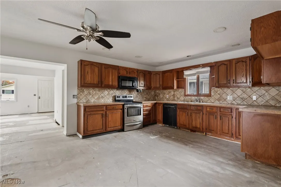 Kitchen with sink, backsplash, stove, microwave, dishwasher, cabinets, ceiling / fan light and plenty of countertop space