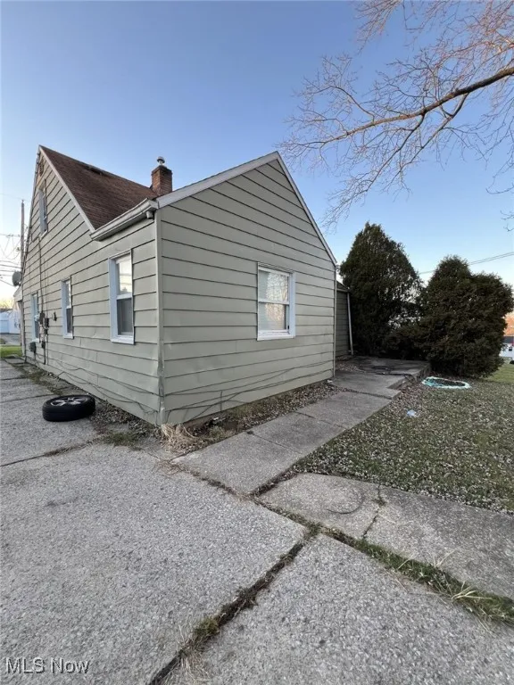 View of property exterior featuring a chimney