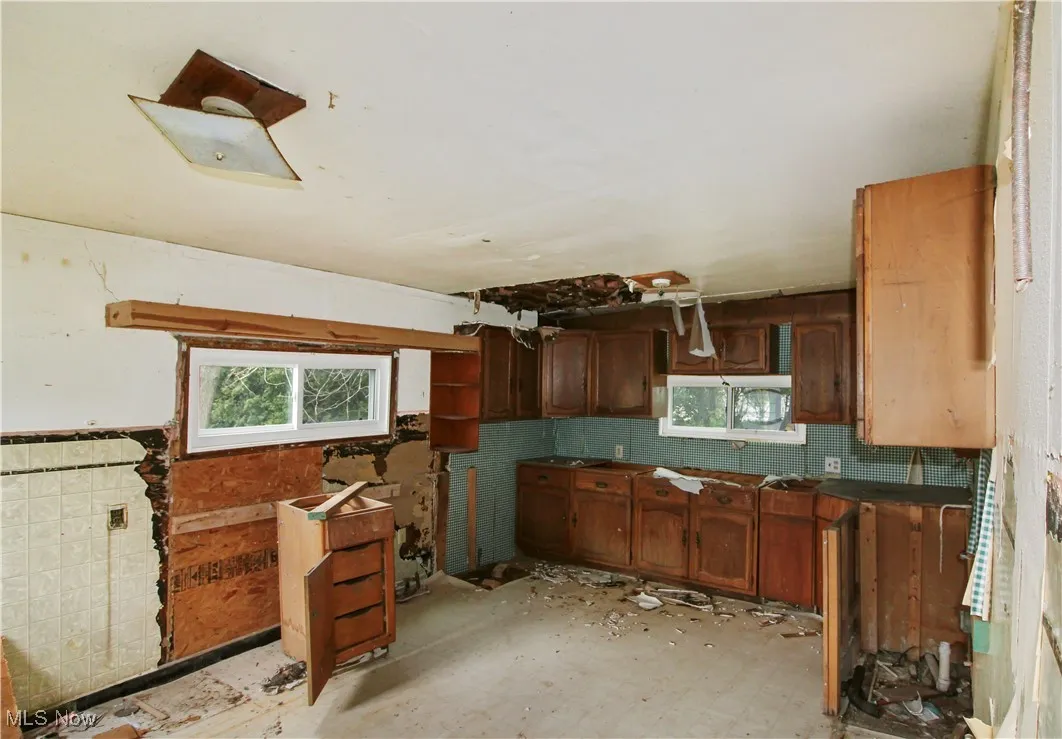 Kitchen featuring dark countertops, tile patterned floors, and brown cabinets