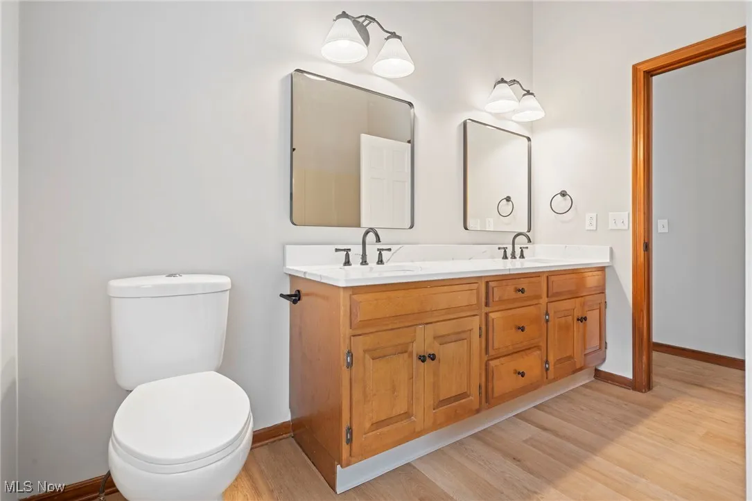 Bathroom with double vanity and light wood finished floors