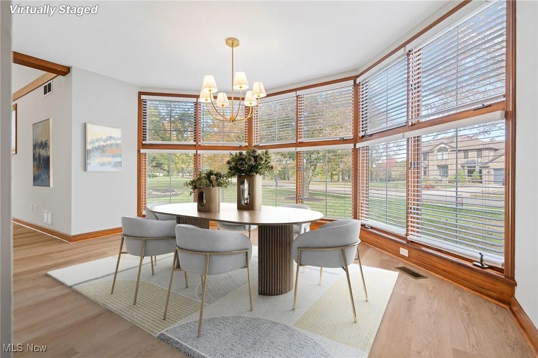 Dining space featuring light wood finished floors and expansive windows