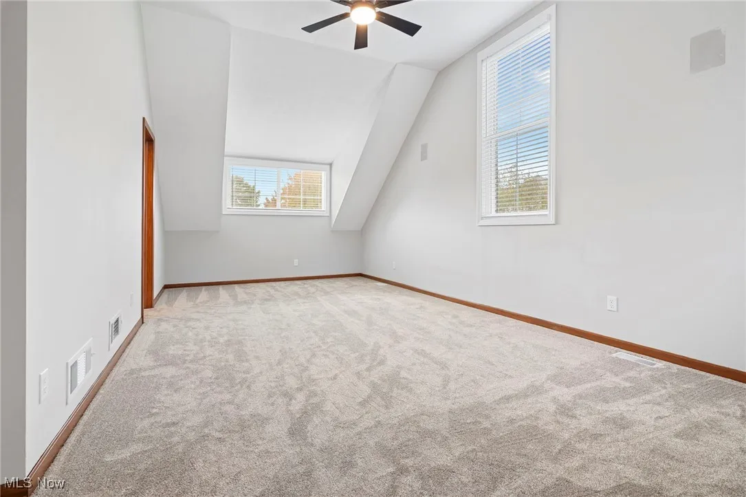 Bonus room featuring lofted ceiling, carpet flooring, and a ceiling fan