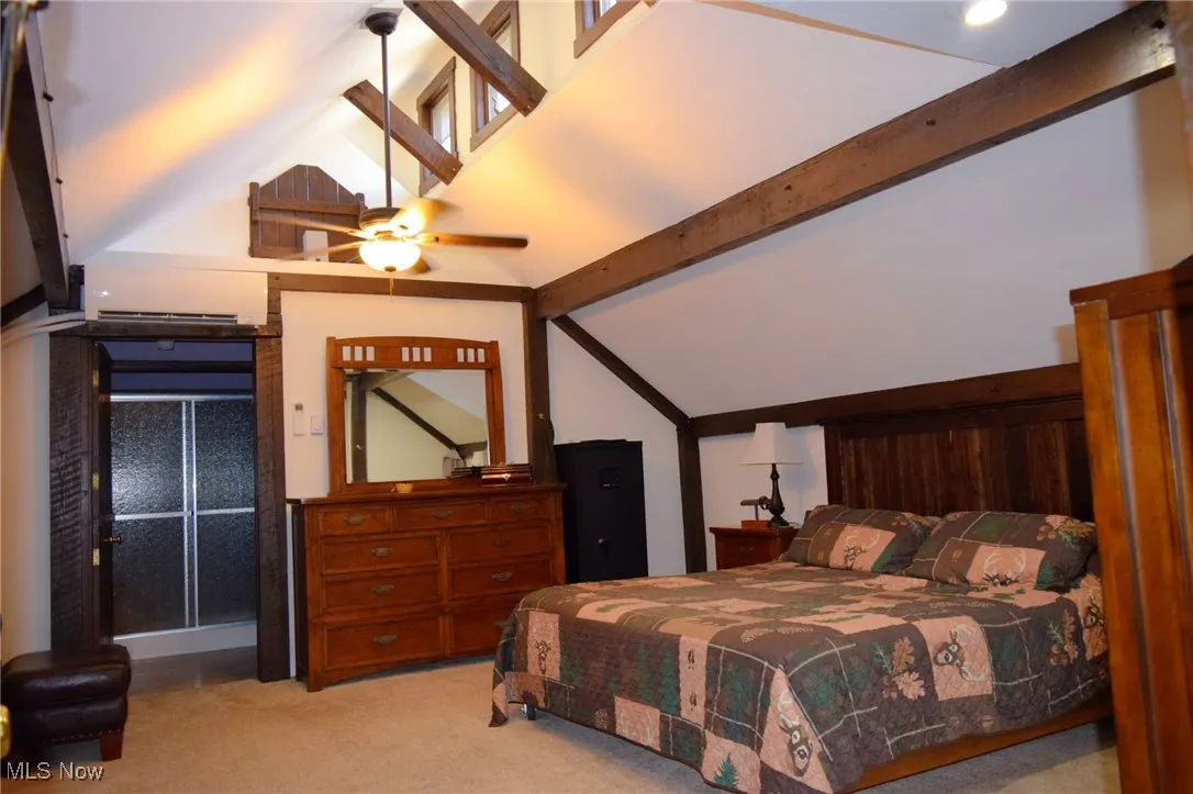 Carpeted bedroom featuring a wall mounted AC and ceiling fan