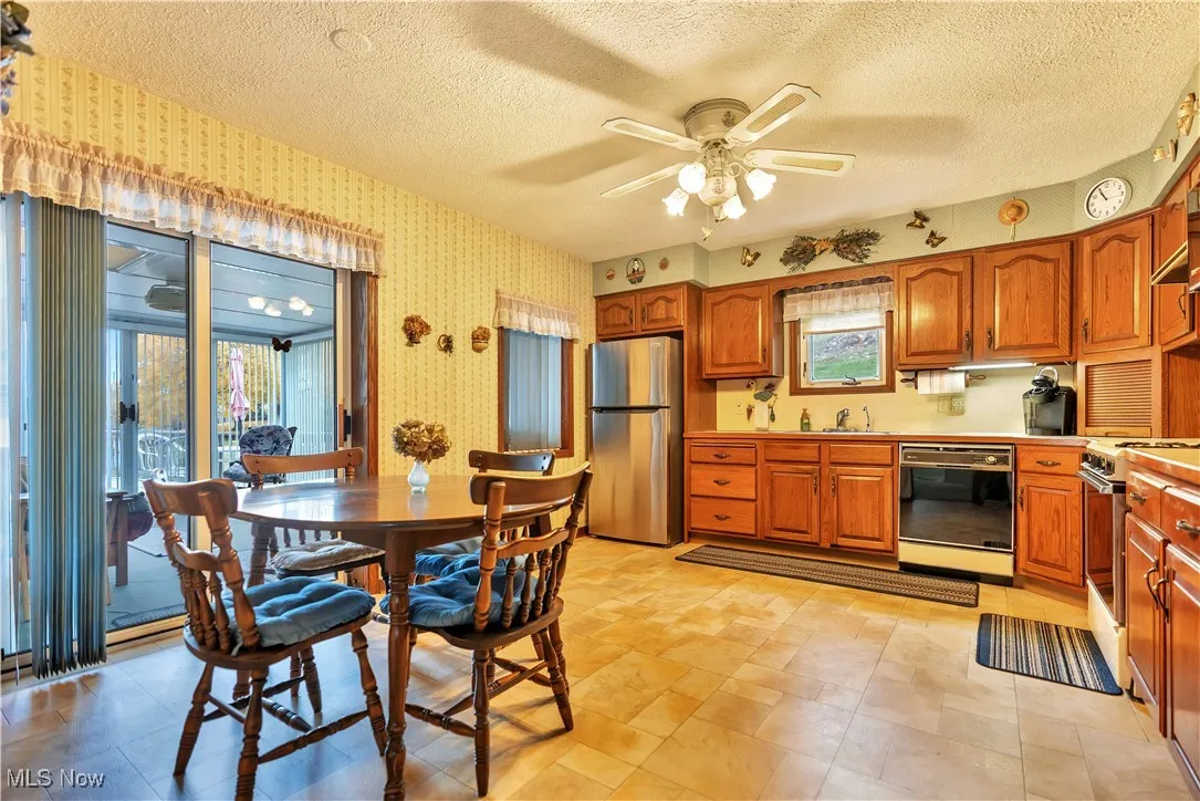 Kitchen with full appliances and ceiling fan and access to the sunroom