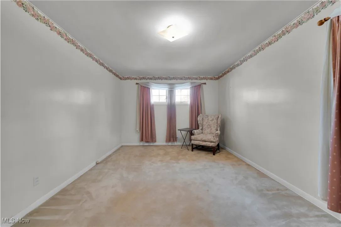 Unfurnished room with light carpet and baseboards