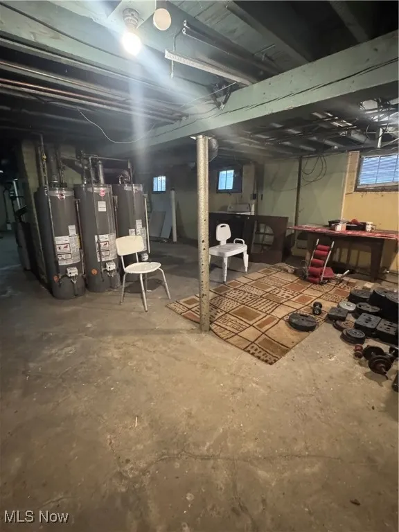 Below grade area featuring water heater and washer / dryer