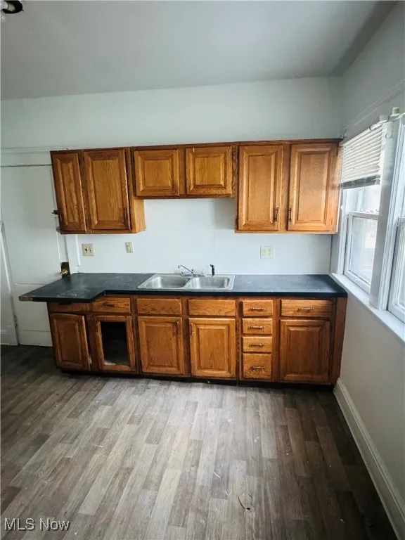 Kitchen featuring dark countertops, brown cabinets, and dark wood-type flooring