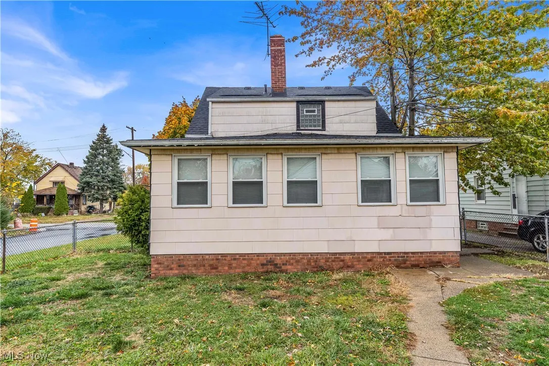 View of property exterior with a chimney and a shingled roof