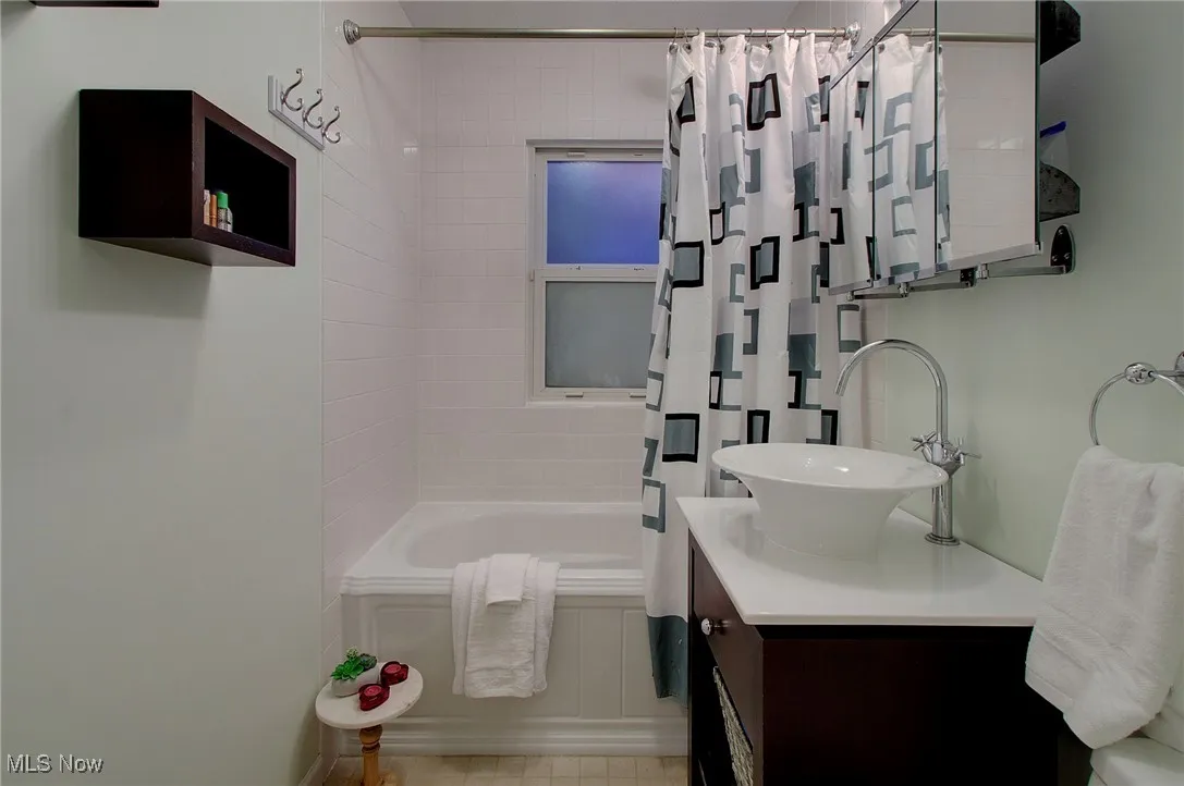 Full bath featuring shower / bath combo with shower curtain and vanity