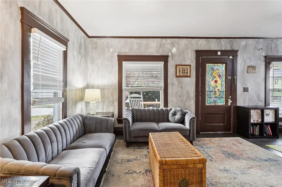 Living room with plenty of natural light, ornamental molding, and wood finished floors