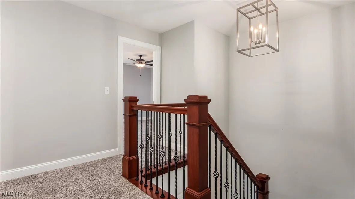 Stairs with carpet and a chandelier