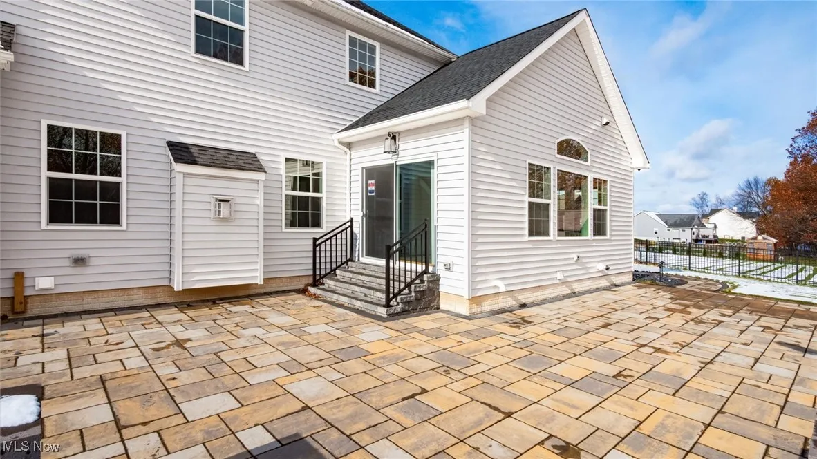 Back of house featuring a patio, a shingled roof, and entry steps