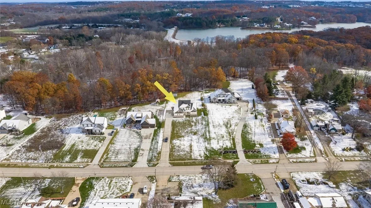 Aerial view of property and surrounding area with a nearby body of water and nearby suburban area