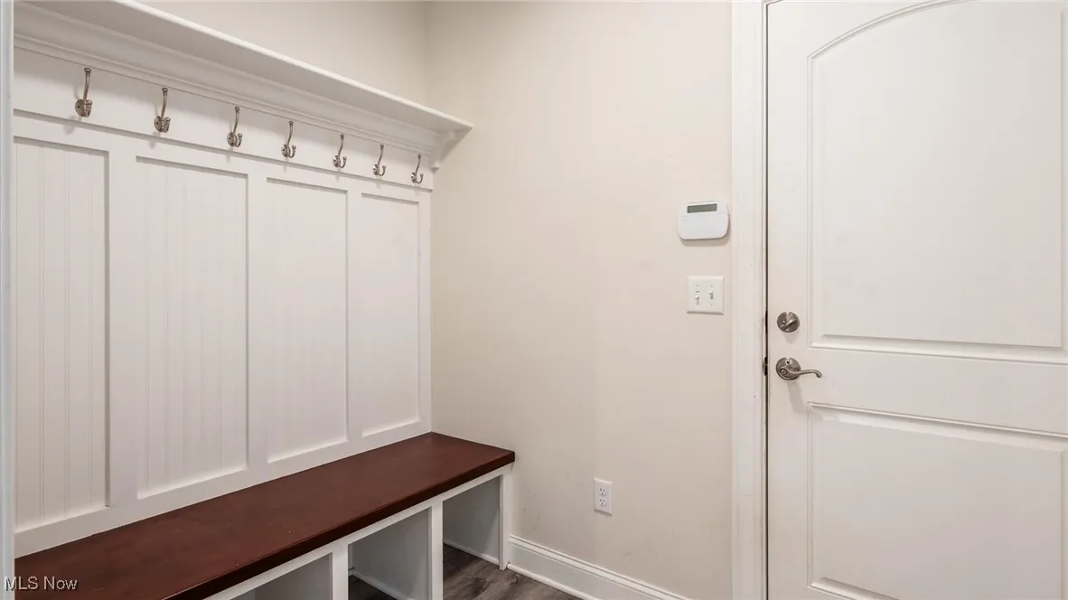 Mudroom featuring baseboards and dark wood-style floors