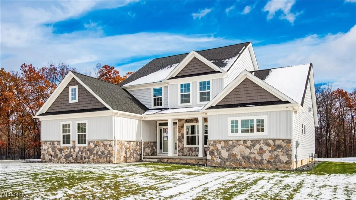 Craftsman house with stone siding, covered porch, and board and batten siding
