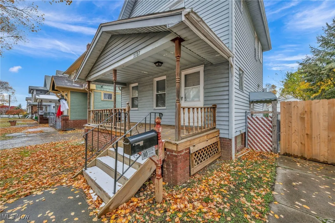 View of front of home featuring covered porch and a gate