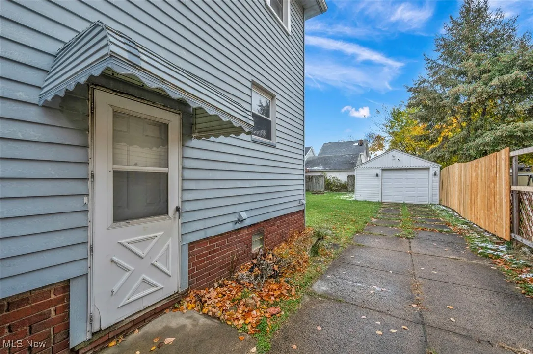 View of home's exterior with a detached garage, crawl space, an outdoor structure, and driveway