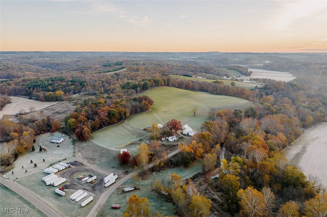 Aerial view of property and surrounding area featuring a forest