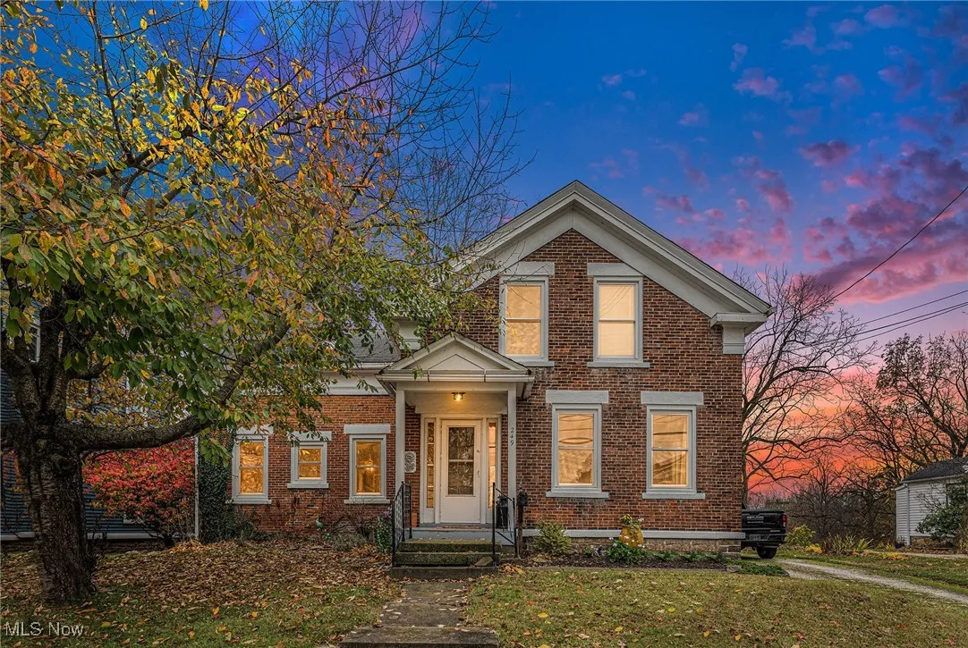 View of front of house featuring brick siding and a lawn