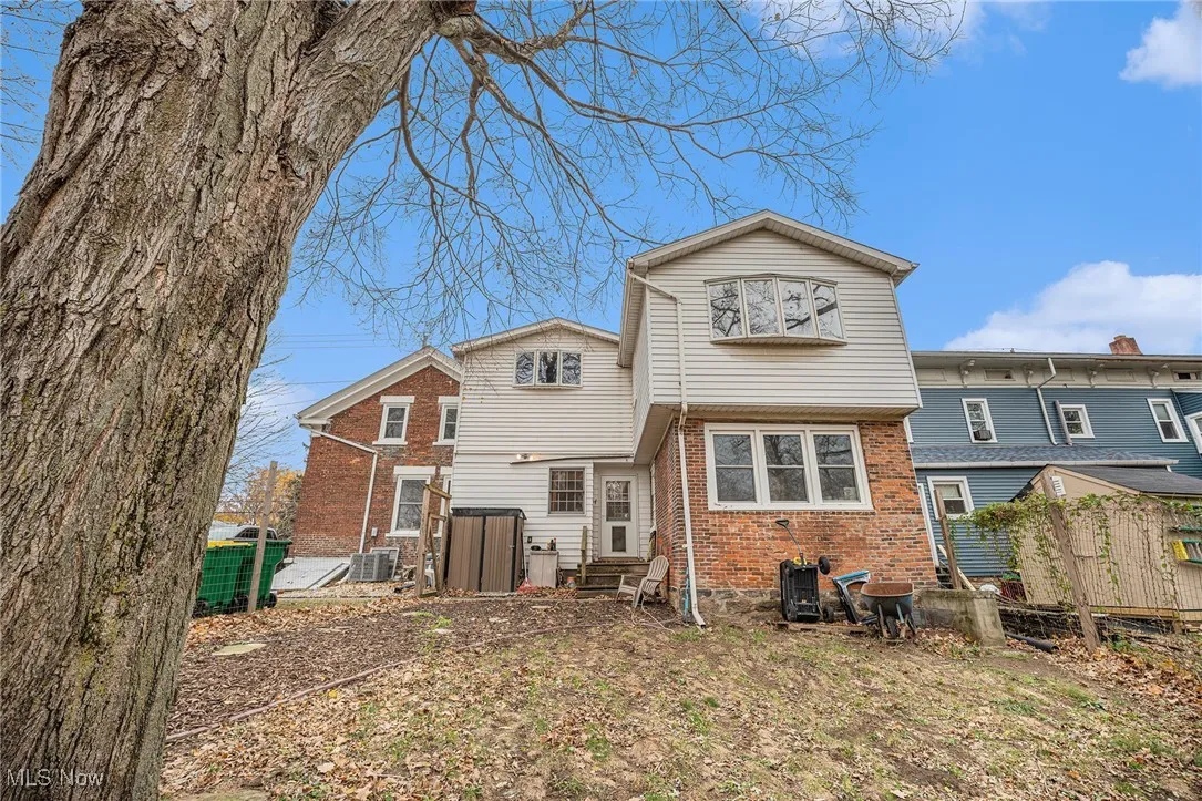 Rear view of property with brick siding and entry steps