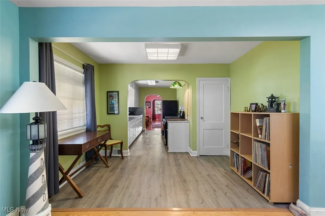 Dining room with arched walkways and light wood-style flooring