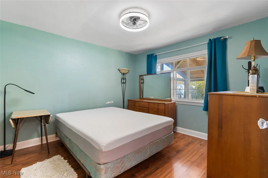 Bedroom featuring baseboards and dark wood-style floors