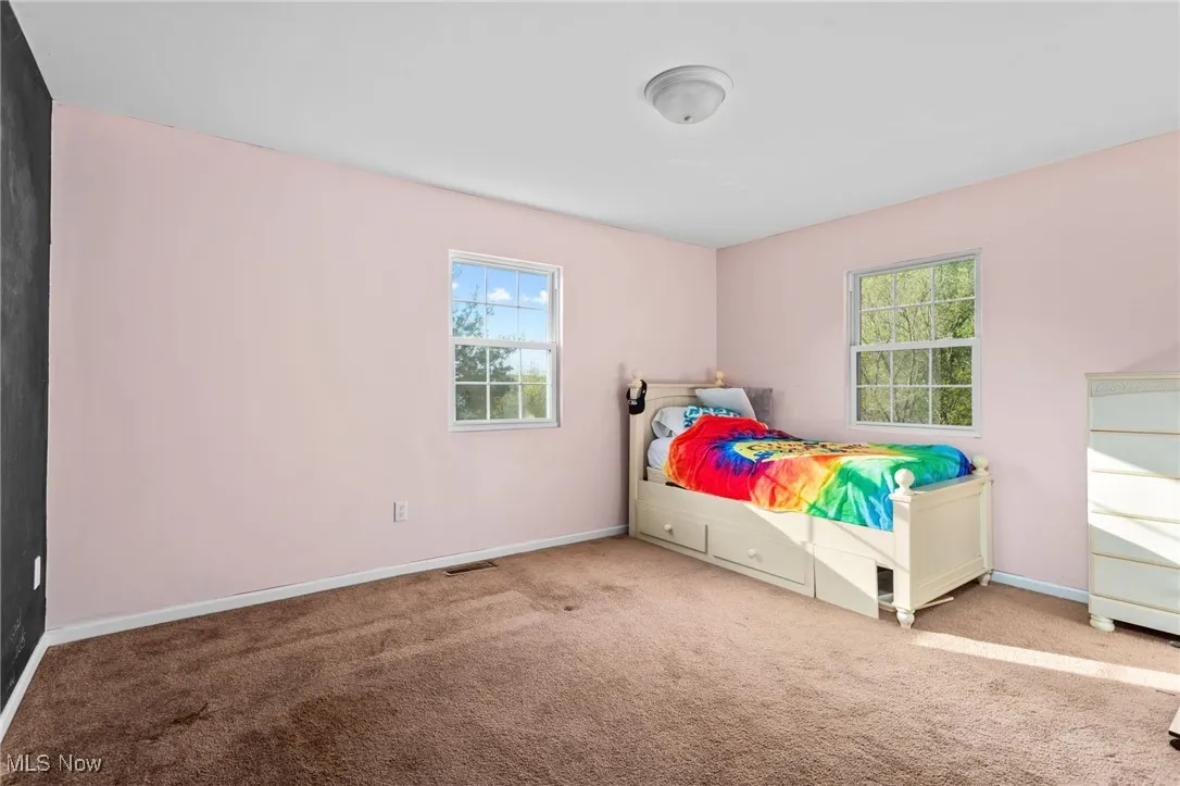 Bedroom with carpet floors and a chalkboard wall