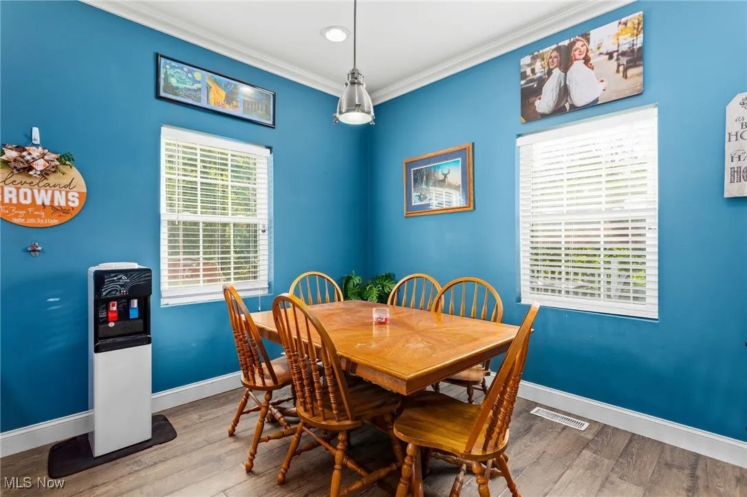 Dining space with wood finished floors and ornamental molding