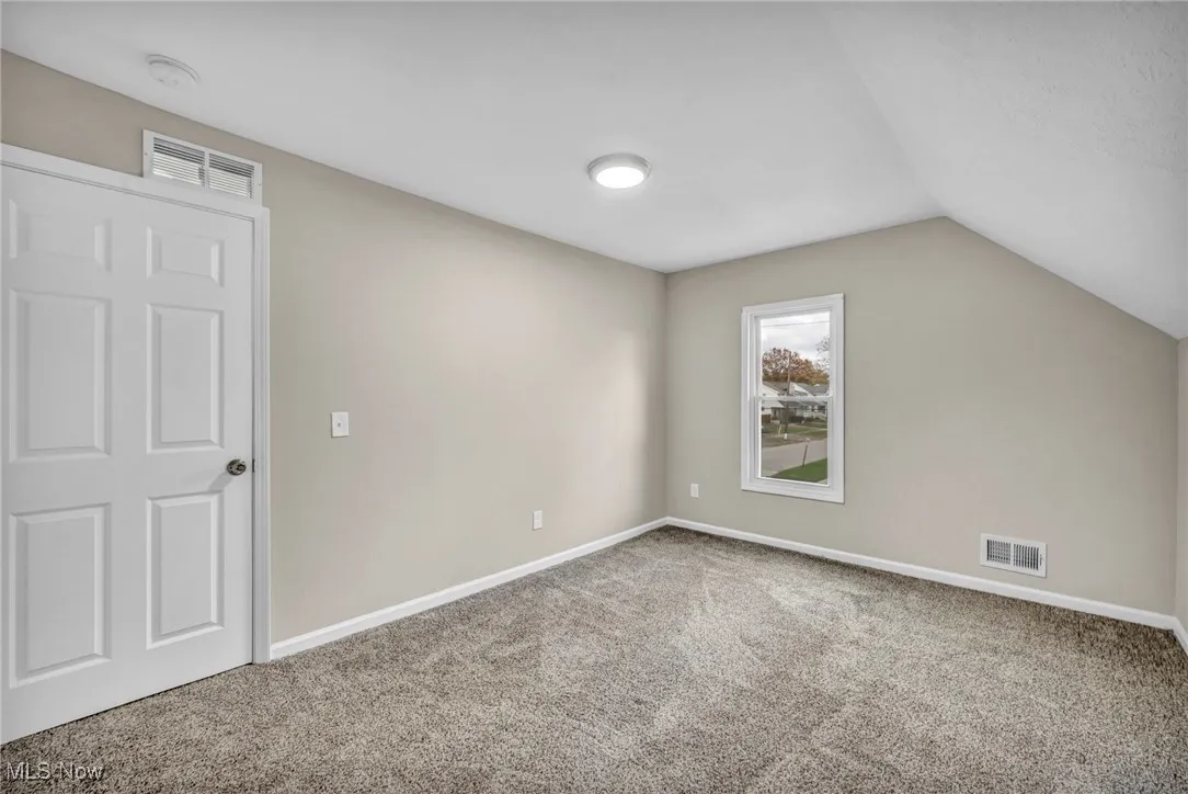 Bonus room featuring carpet flooring and vaulted ceiling