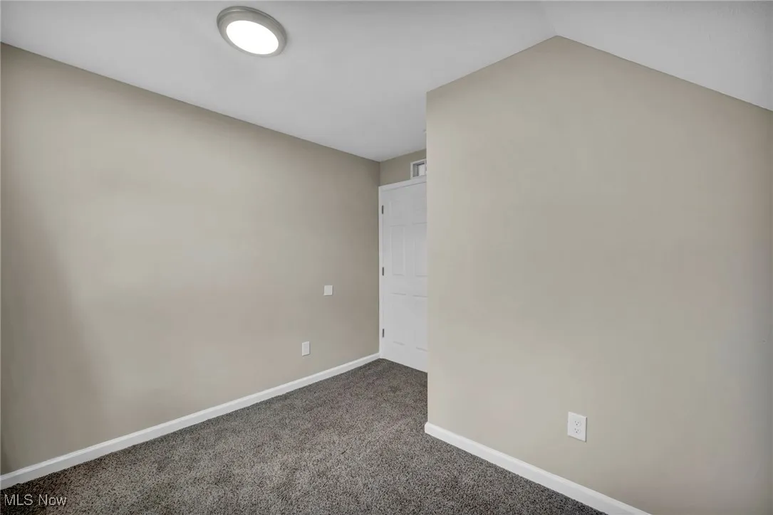 Empty room featuring carpet and baseboards